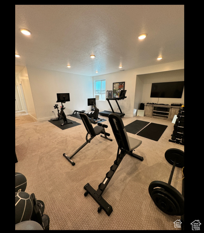 Exercise area featuring carpet flooring, baseboards, recessed lighting, and a textured ceiling
