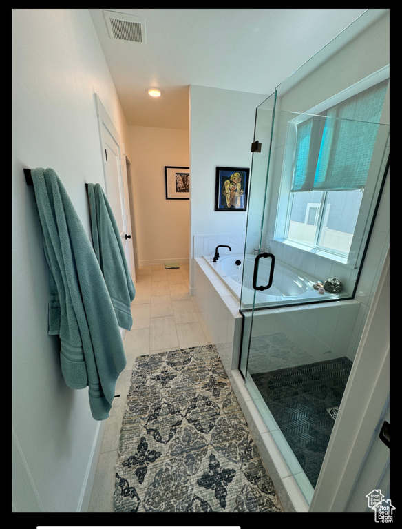 Full bath featuring a garden tub, a stall shower, tile patterned flooring, and baseboards