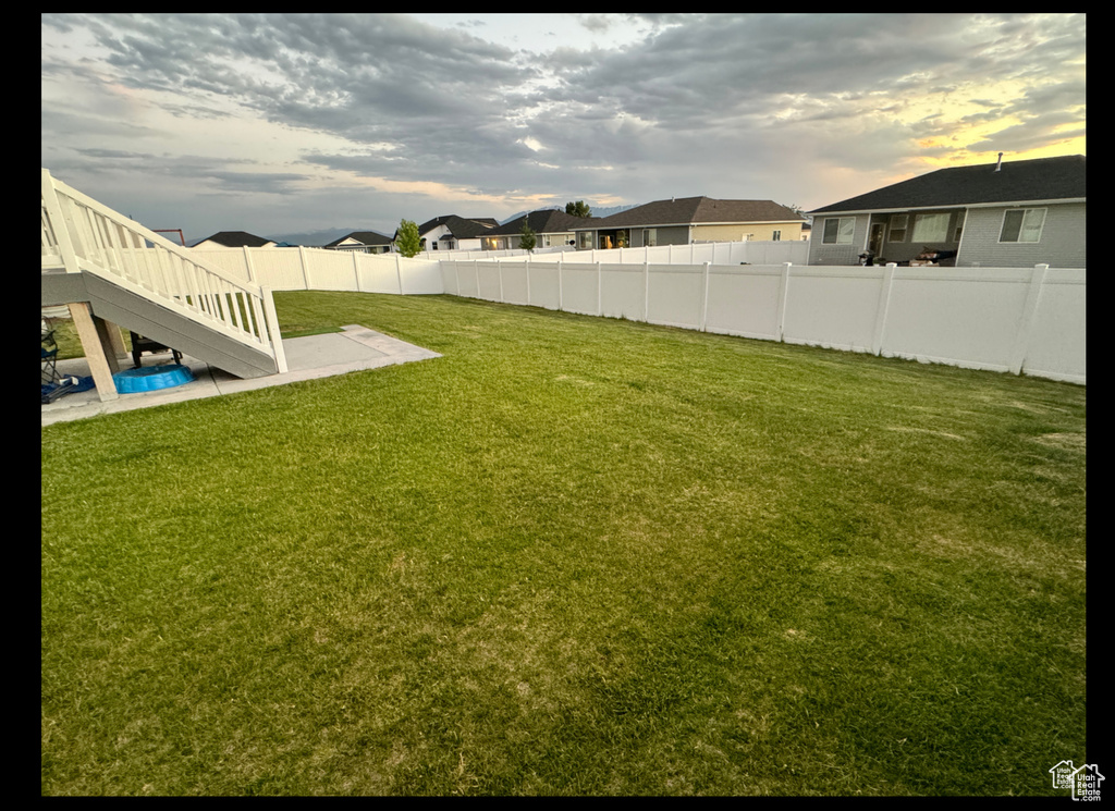 View of yard with stairway, a patio, and a residential view