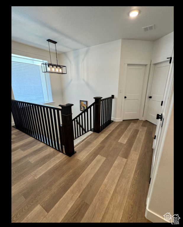 Hall with an upstairs landing and wood finished floors