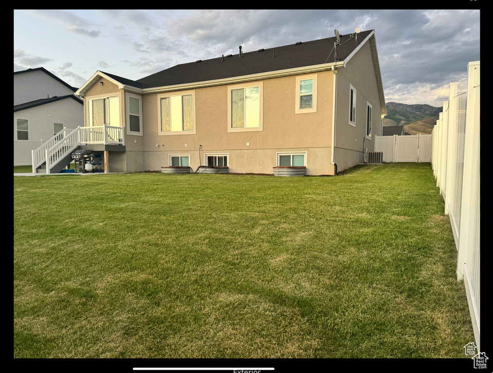 Rear view of house featuring stucco siding and cooling unit