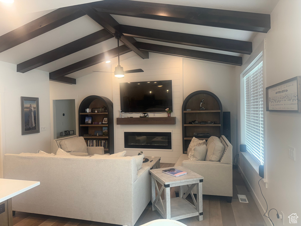 Living area featuring wood finished floors, a large fireplace, and plenty of natural light