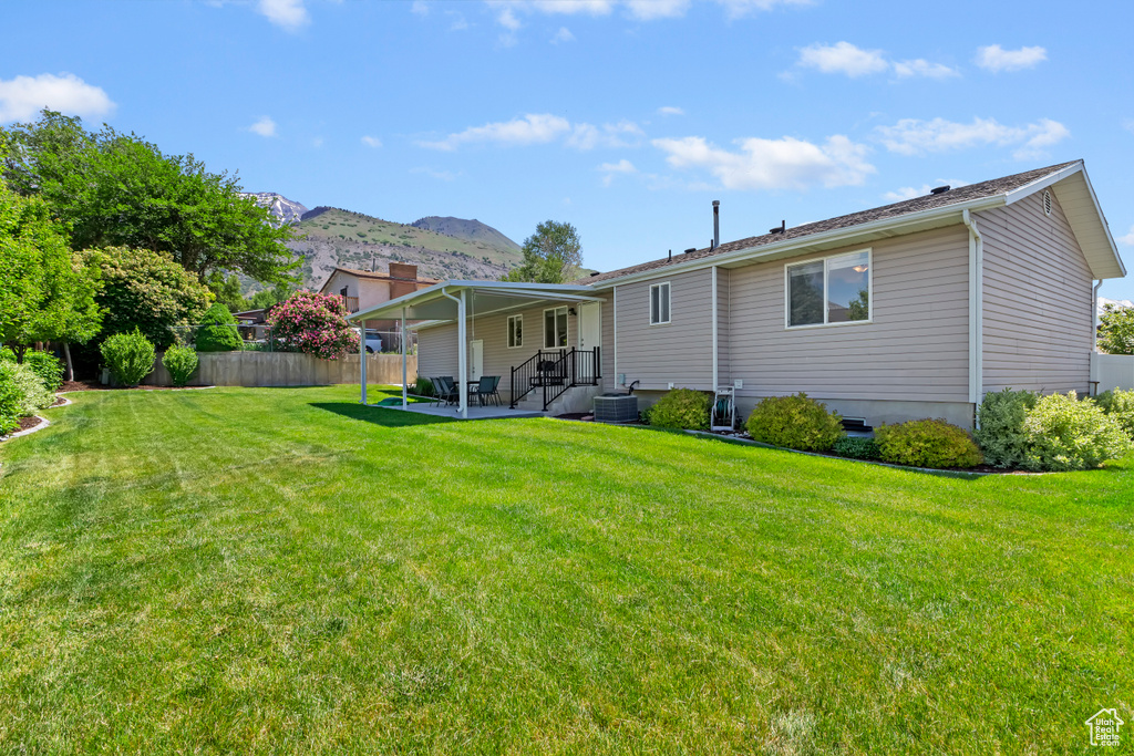 Back of property featuring a mountain view, a patio, and central AC
