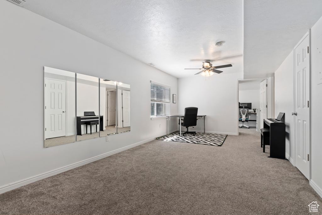 Living area with carpet floors, ceiling fan, an office area, and baseboards