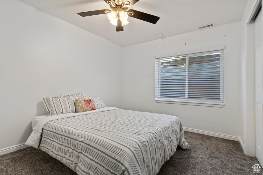 Carpeted bedroom featuring baseboards and ceiling fan