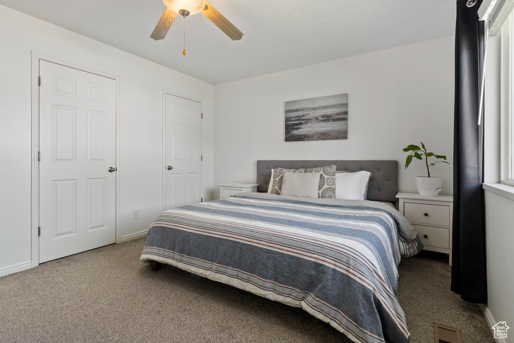 Bedroom with carpet floors, ceiling fan, and baseboards