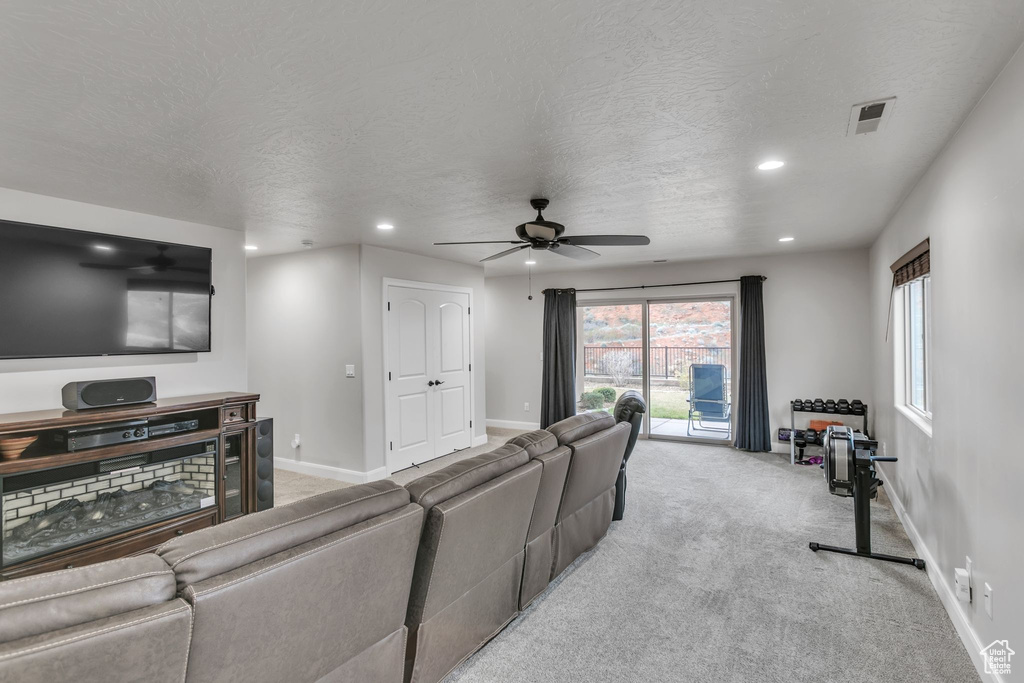 Living area featuring a ceiling fan, recessed lighting, baseboards, light colored carpet, and healthy amount of natural light