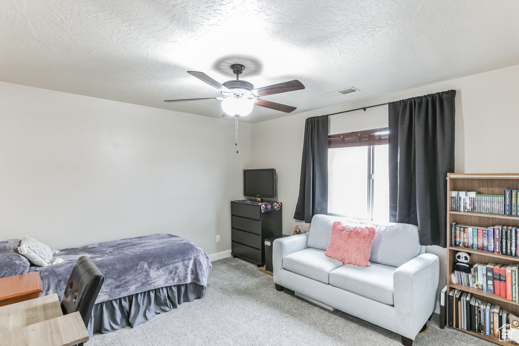 Bedroom with carpet, a ceiling fan, baseboards, and a textured ceiling