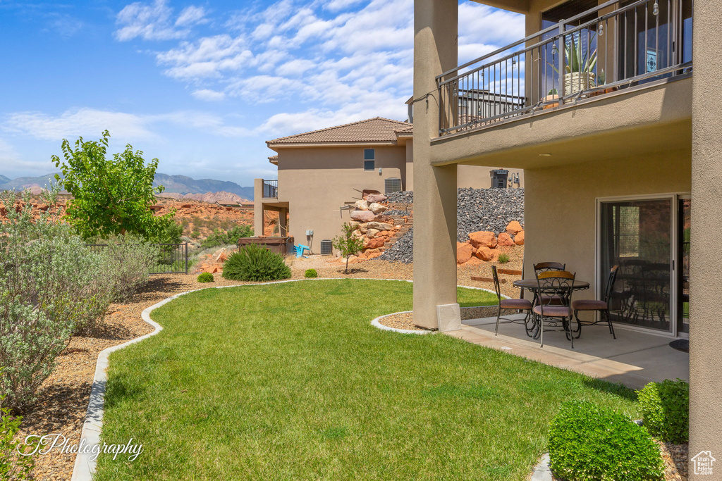 View of yard featuring a balcony, a patio area, and a mountain view