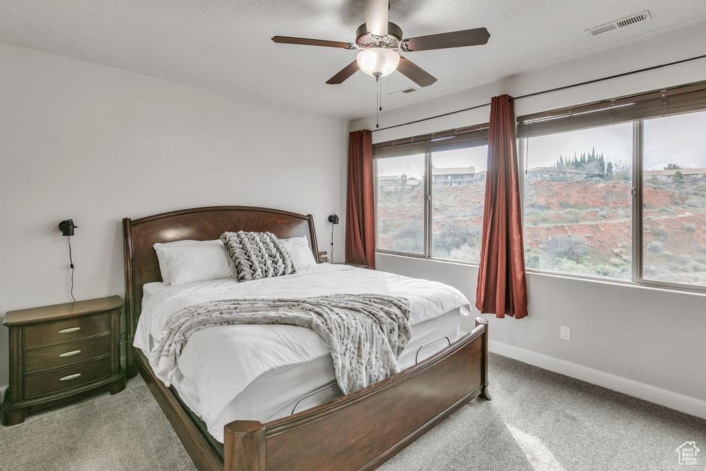 Carpeted bedroom with baseboards and a ceiling fan