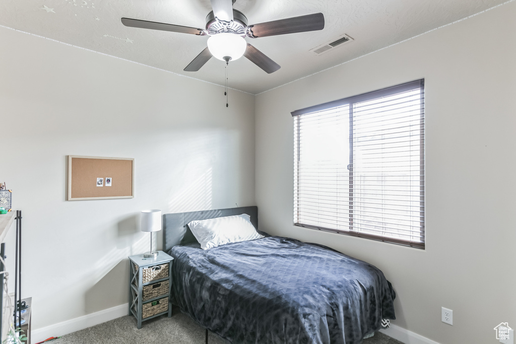Bedroom with baseboards, carpet flooring, and a ceiling fan