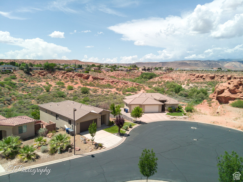 Aerial view of property and surrounding area featuring mountains and a desert landscape