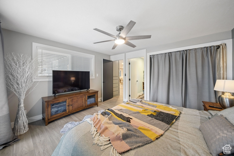 Bedroom with light wood-style flooring, ceiling fan, and baseboards