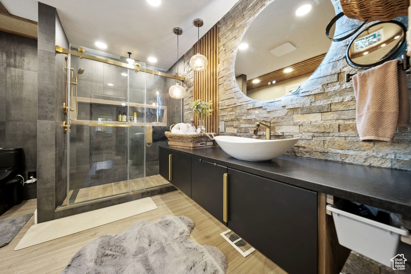Full bathroom with vanity, a stall shower, toilet, and wood finished floors