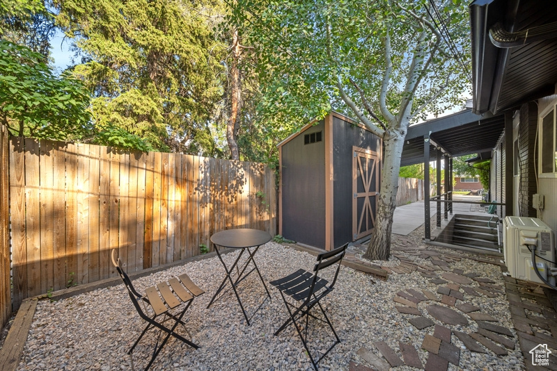 Fenced backyard with a patio area and a cooling unit