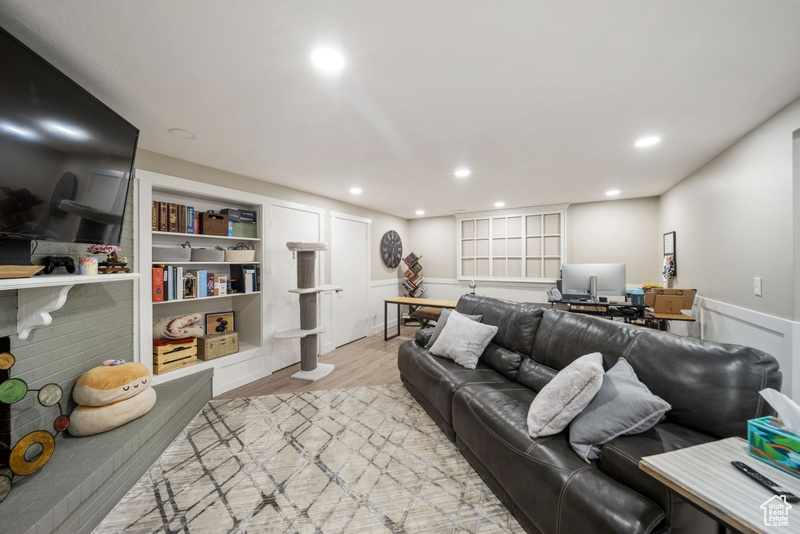 Living room featuring an office area, light wood finished floors, and recessed lighting