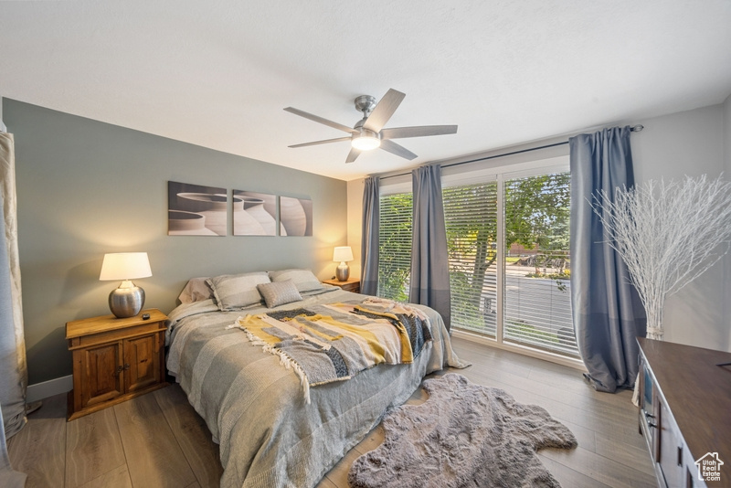 Bedroom featuring wood finished floors, access to exterior, and ceiling fan