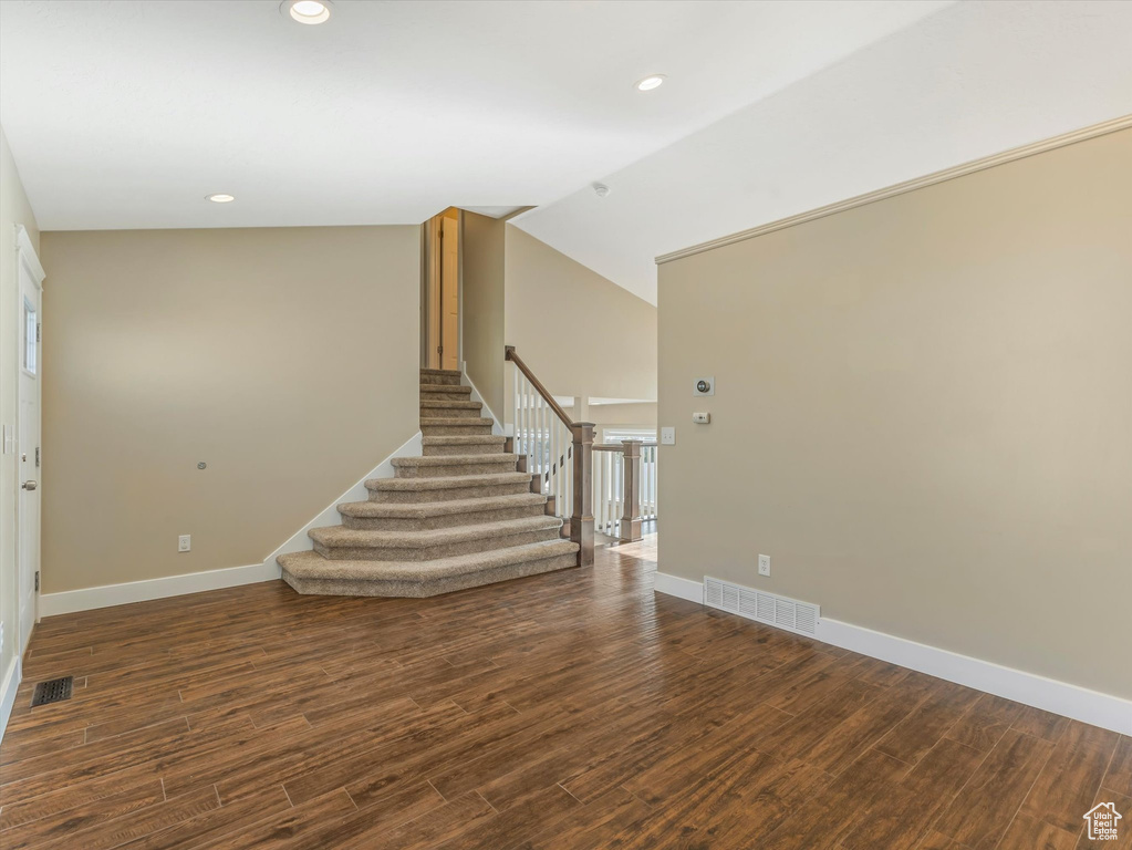 Stairs featuring wood finished floors, baseboards, recessed lighting, and lofted ceiling