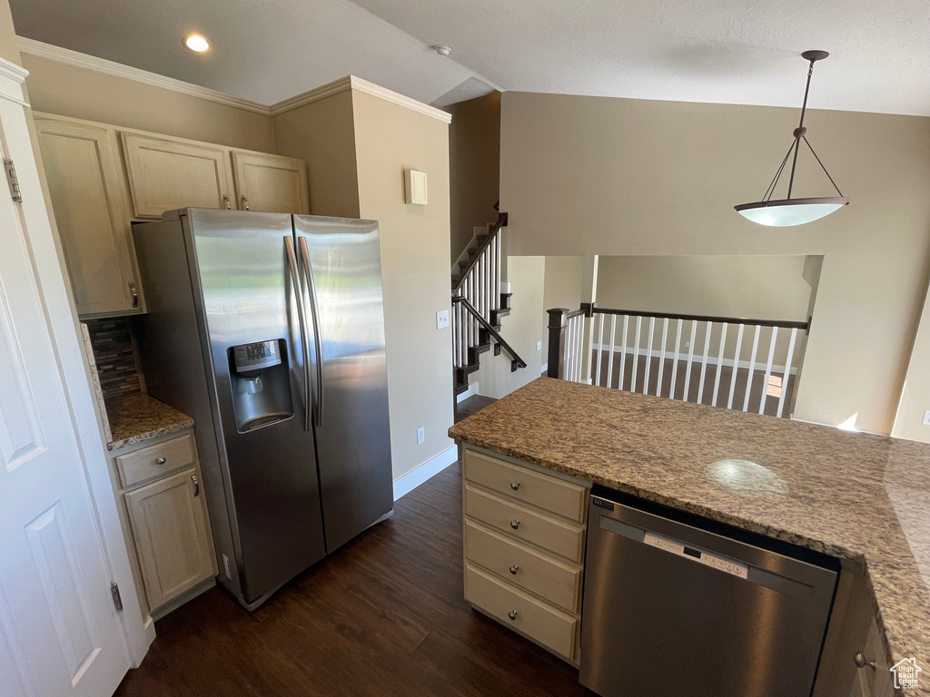 Kitchen with appliances with stainless steel finishes, dark wood finished floors, lofted ceiling, decorative light fixtures, and baseboards