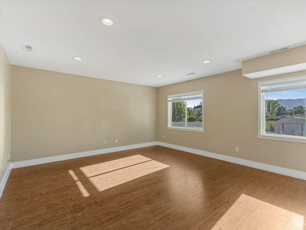Empty room with wood finished floors, baseboards, and recessed lighting