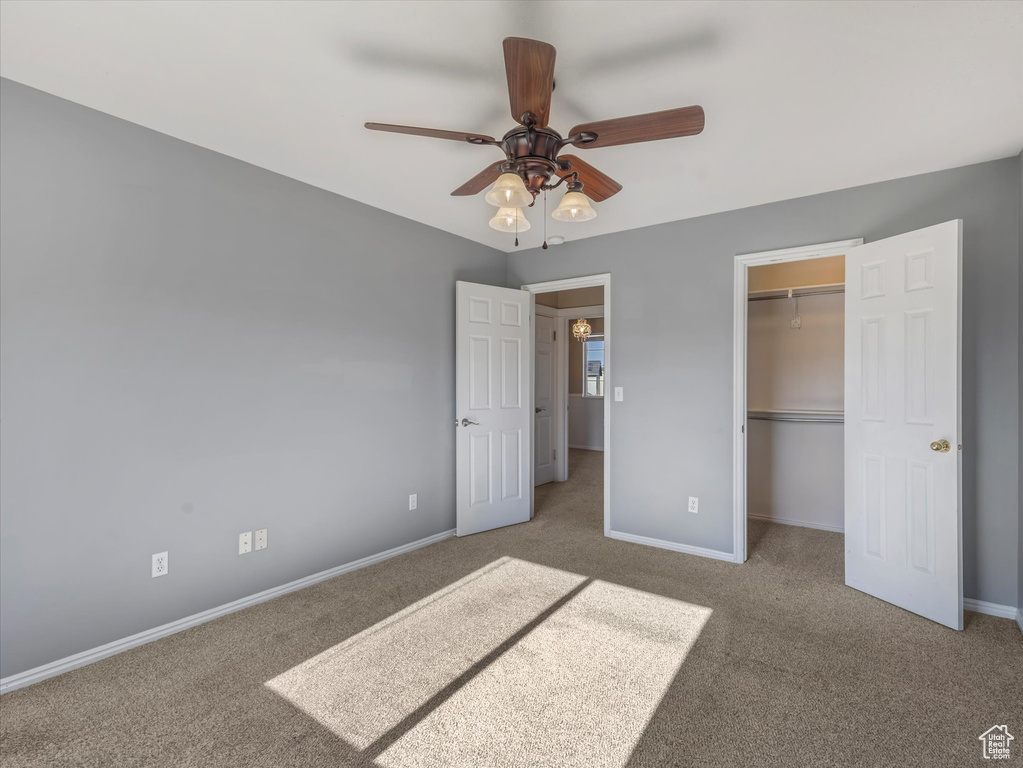 Unfurnished bedroom with carpet, baseboards, a closet, and ceiling fan