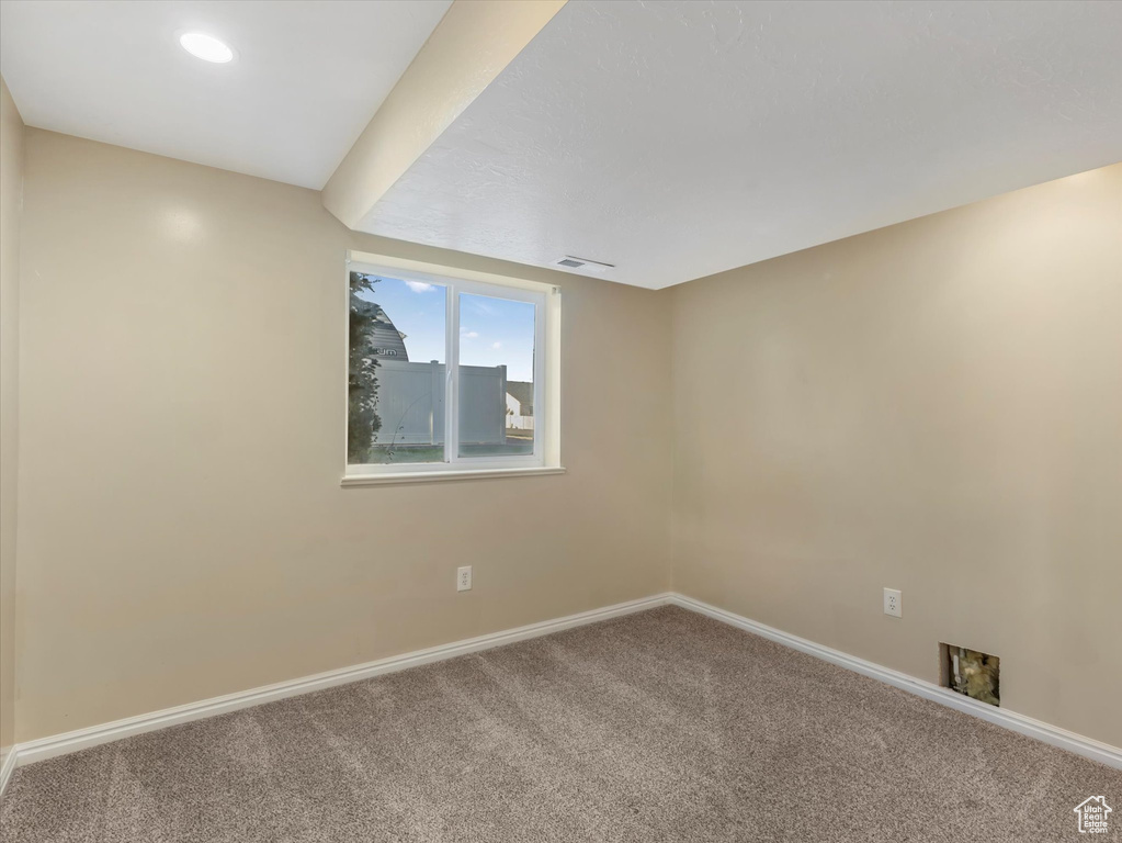 Carpeted empty room with baseboards
