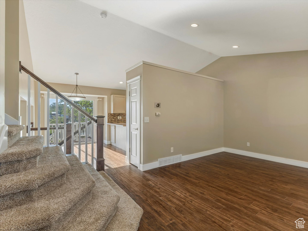 Staircase with wood finished floors, vaulted ceiling, baseboards, and recessed lighting