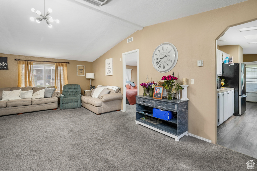 Living room featuring carpet floors, healthy amount of natural light, arched walkways, and a chandelier