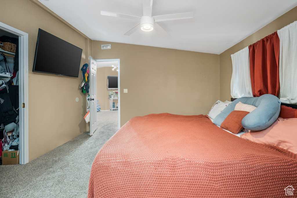 Bedroom with light carpet, a closet, and a ceiling fan