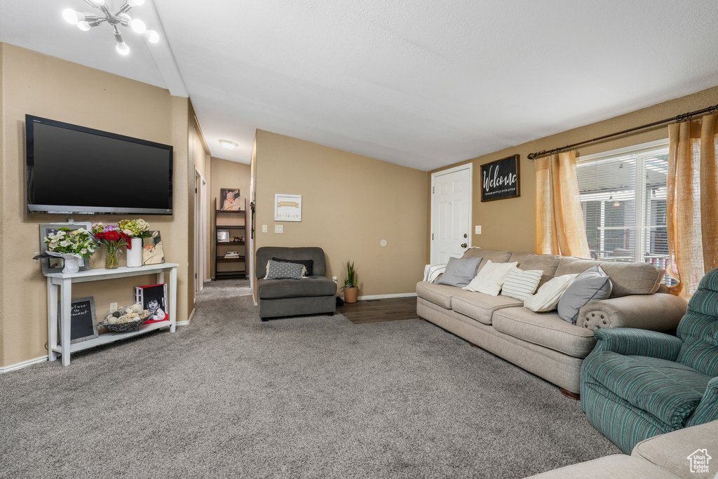Living room with lofted ceiling, carpet, and baseboards