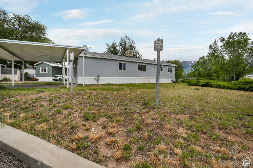 View of side of home featuring an attached carport and a mountain view