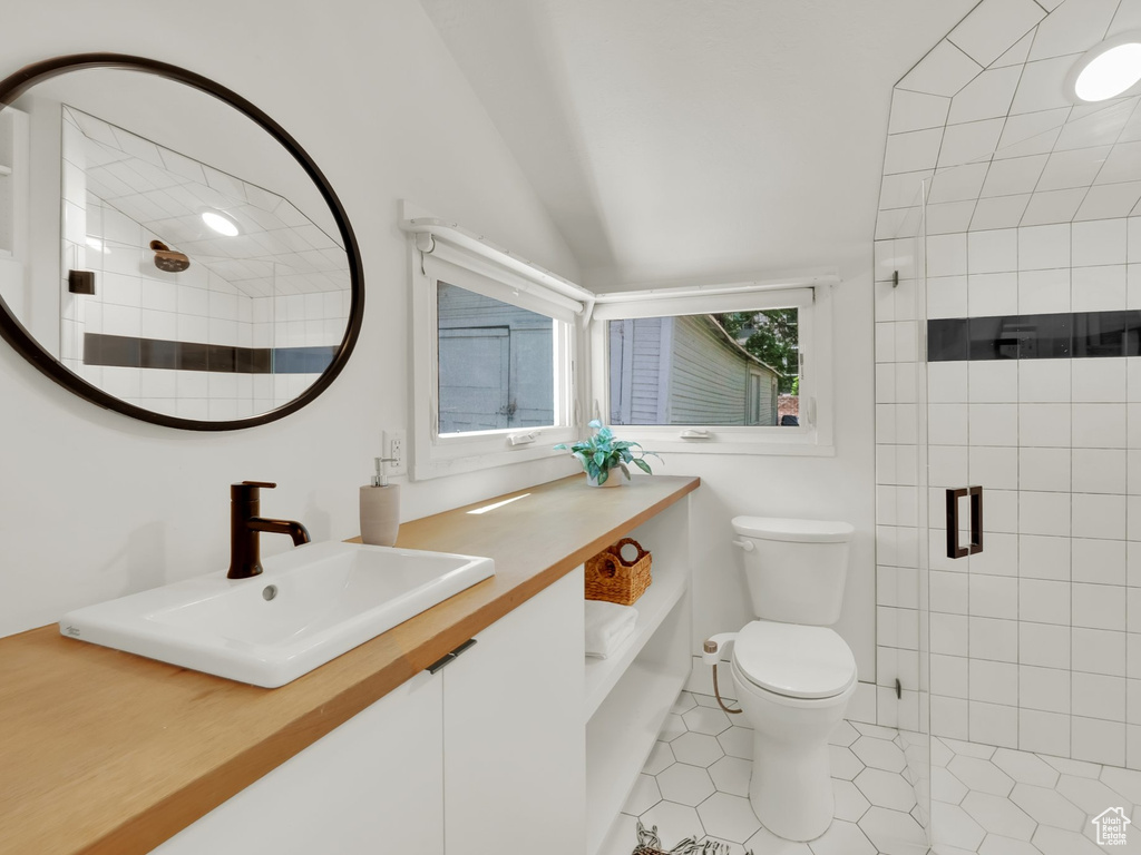 Full bath with toilet, a stall shower, vanity, and tile patterned floors