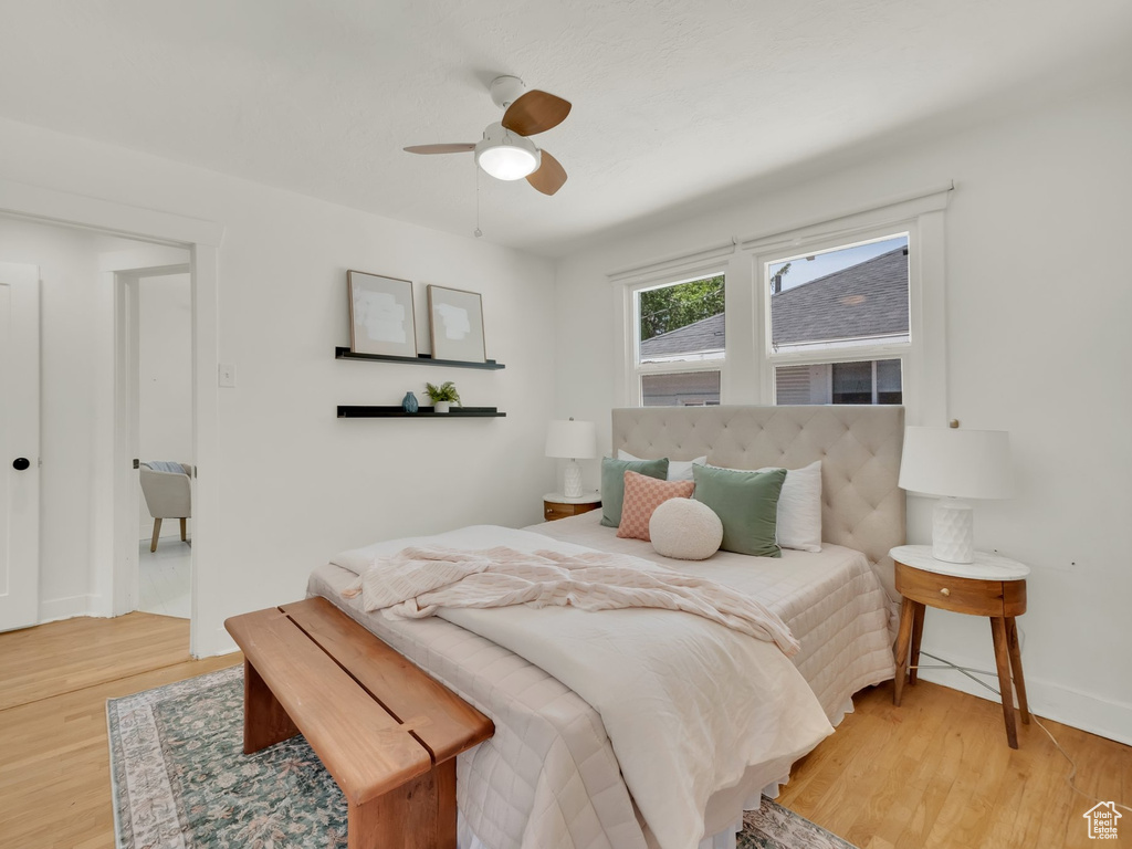 Bedroom featuring light wood-style flooring, baseboards, and a ceiling fan