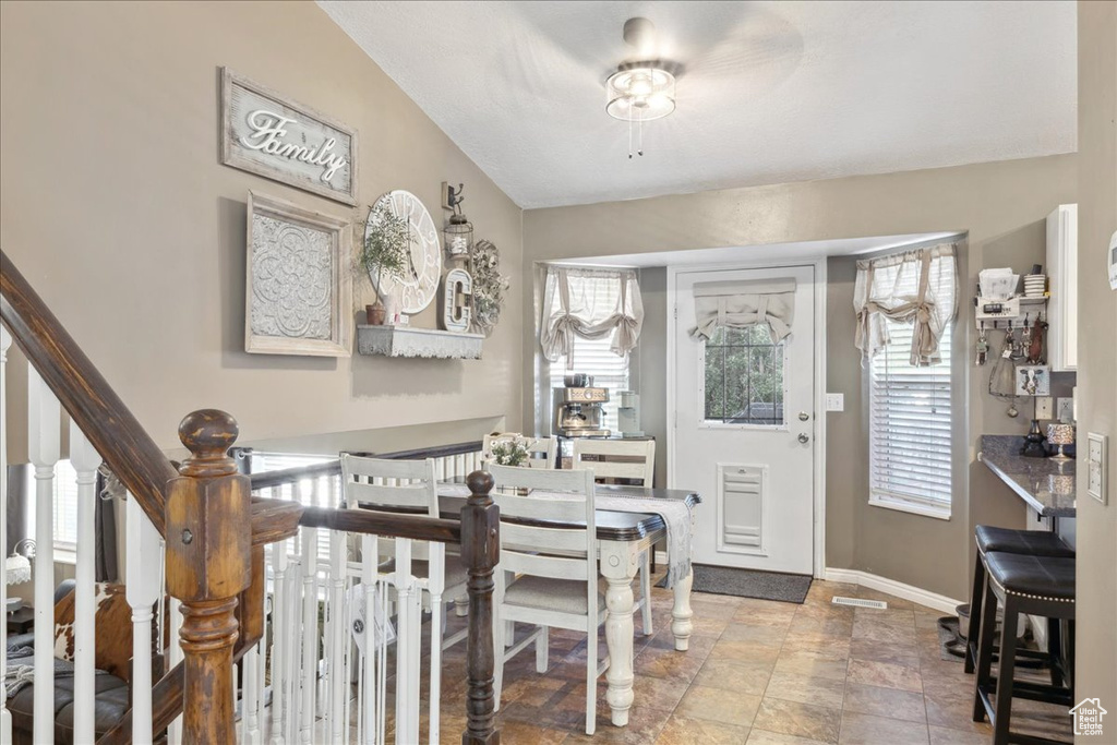Foyer entrance featuring plenty of natural light, baseboards, stone finish flooring, and stairway
