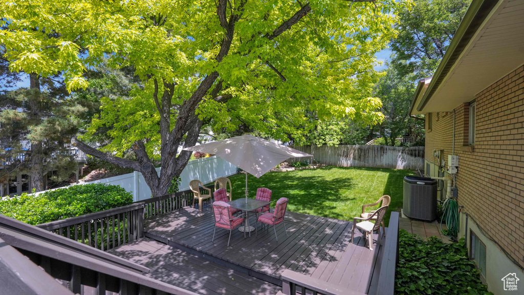 Wooden terrace featuring central air condition unit and outdoor dining area