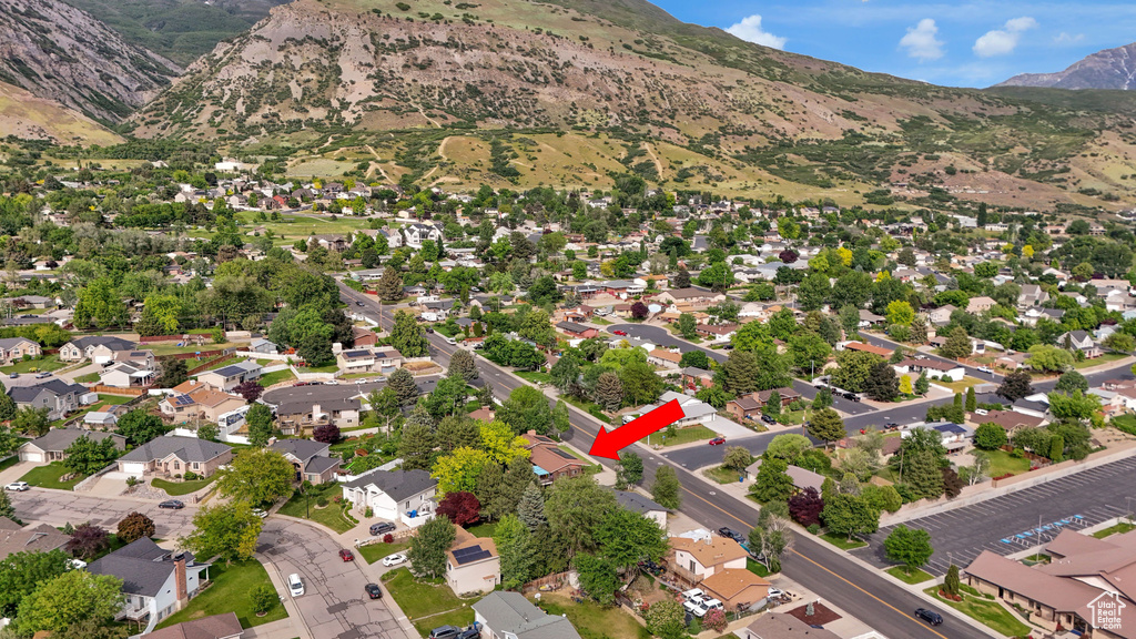 Aerial view of property and surrounding area with a mountain backdrop and nearby suburban area