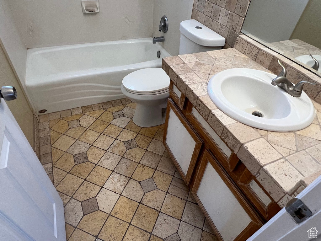 Full bath with toilet, vanity, and bathing tub / shower combination