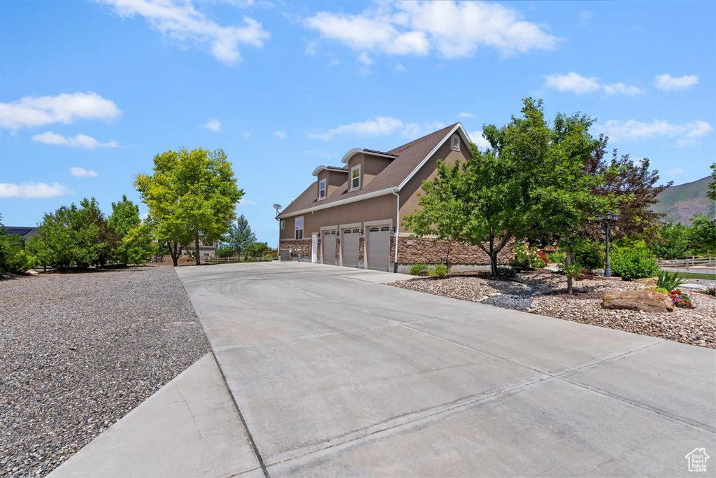 View of side of property featuring concrete driveway and stucco siding