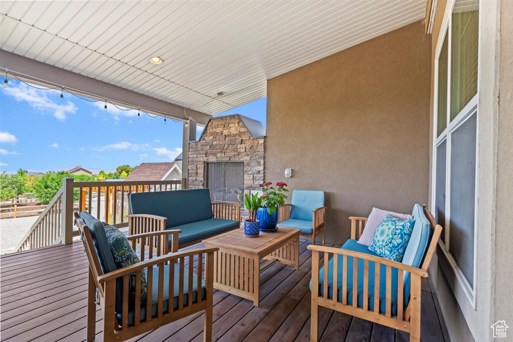 Wooden deck with an outdoor living space with a fireplace
