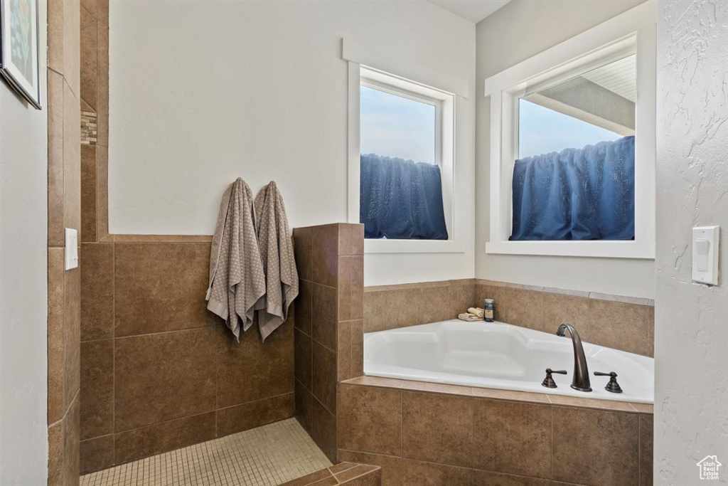 Full bath with a bath and tiled shower