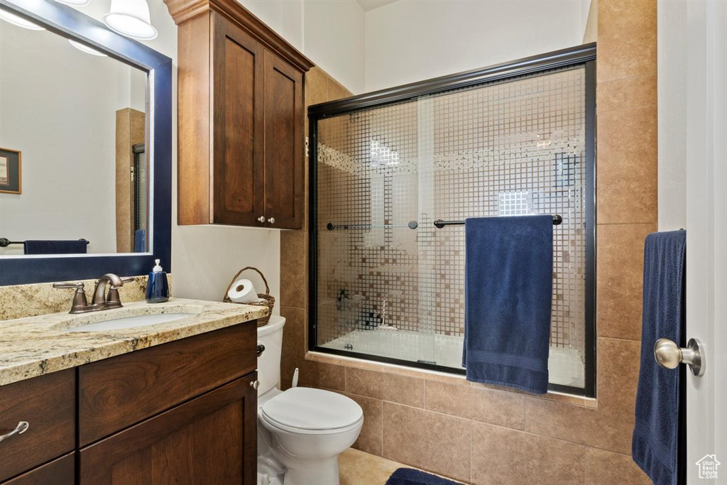 Full bathroom featuring tiled shower / bath, vanity, and toilet