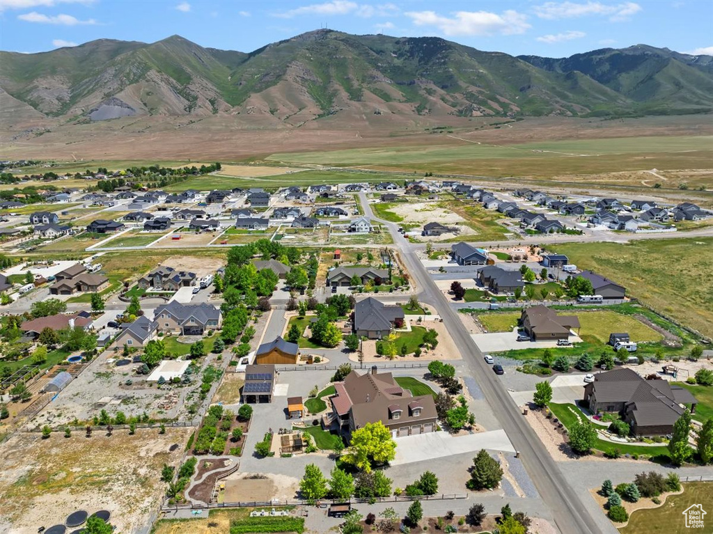Aerial view of property and surrounding area featuring nearby suburban area and a mountainous background