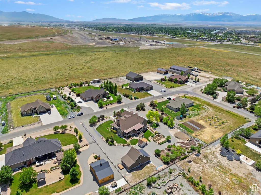 Aerial view of property and surrounding area with nearby suburban area and a mountainous background
