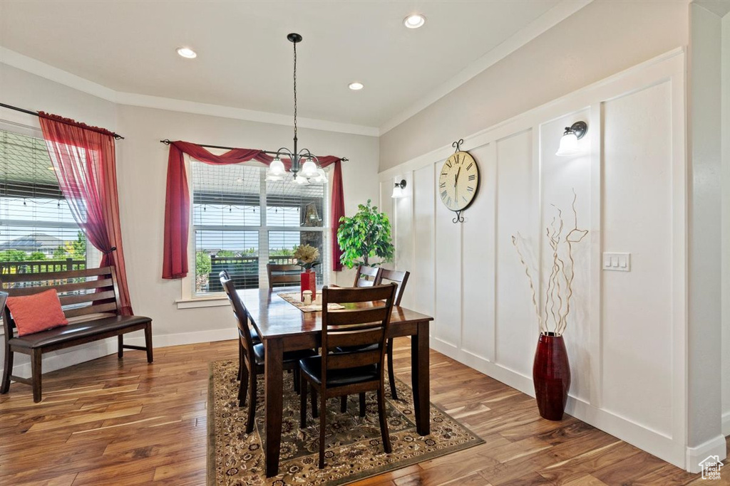 Dining space with crown molding, a chandelier, wood finished floors, recessed lighting, and baseboards