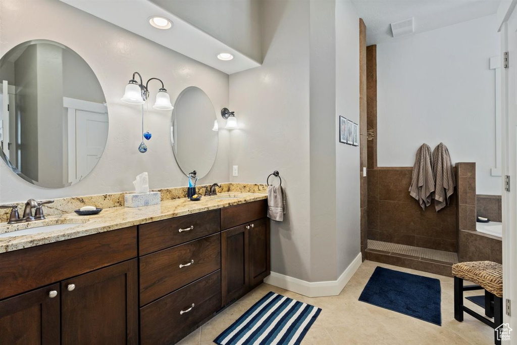Bathroom with double vanity, a bath, tile patterned floors, a walk in shower, and recessed lighting