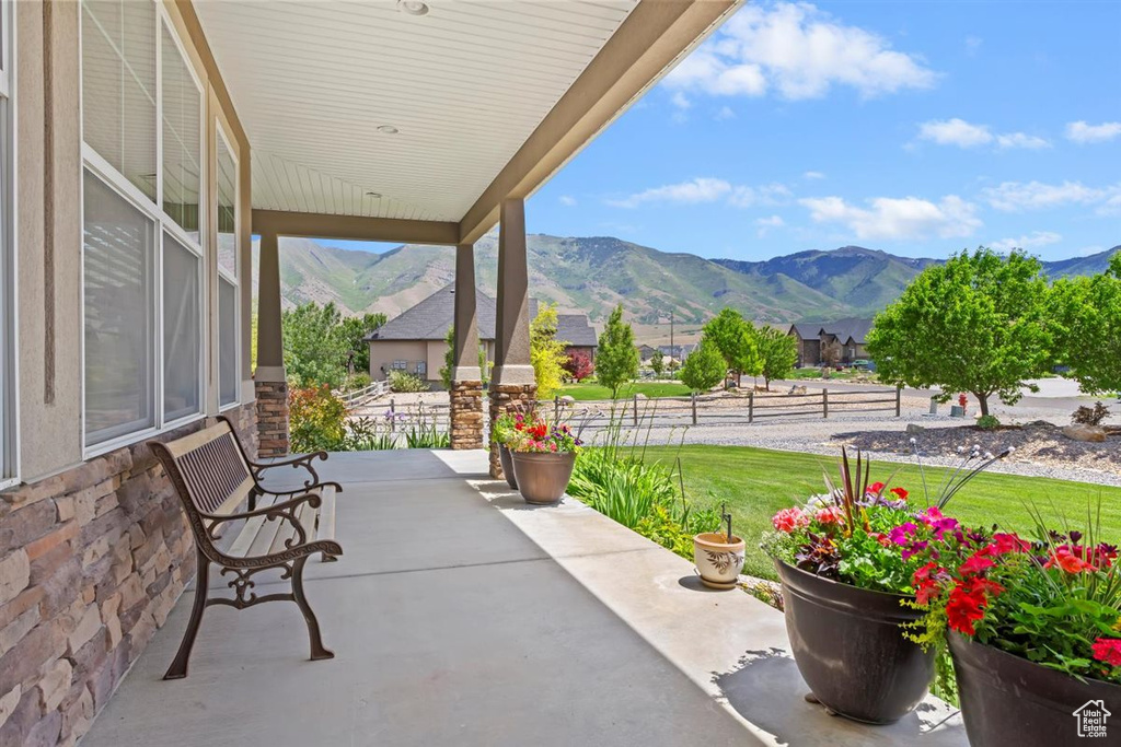 Porch featuring a mountain view and a lawn