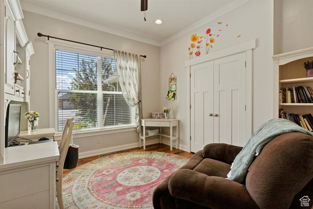 Office area featuring plenty of natural light, baseboards, light wood-style floors, ornamental molding, and a ceiling fan