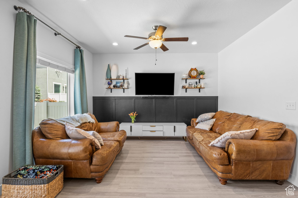 Living room with ceiling fan, light wood-style floors, and recessed lighting