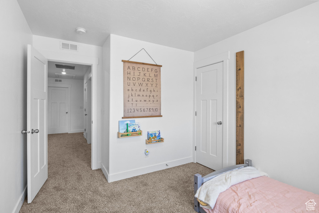 Bedroom featuring carpet and baseboards