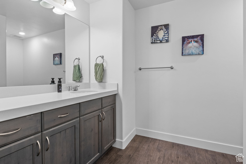 Bathroom with vanity, baseboards, and wood finished floors